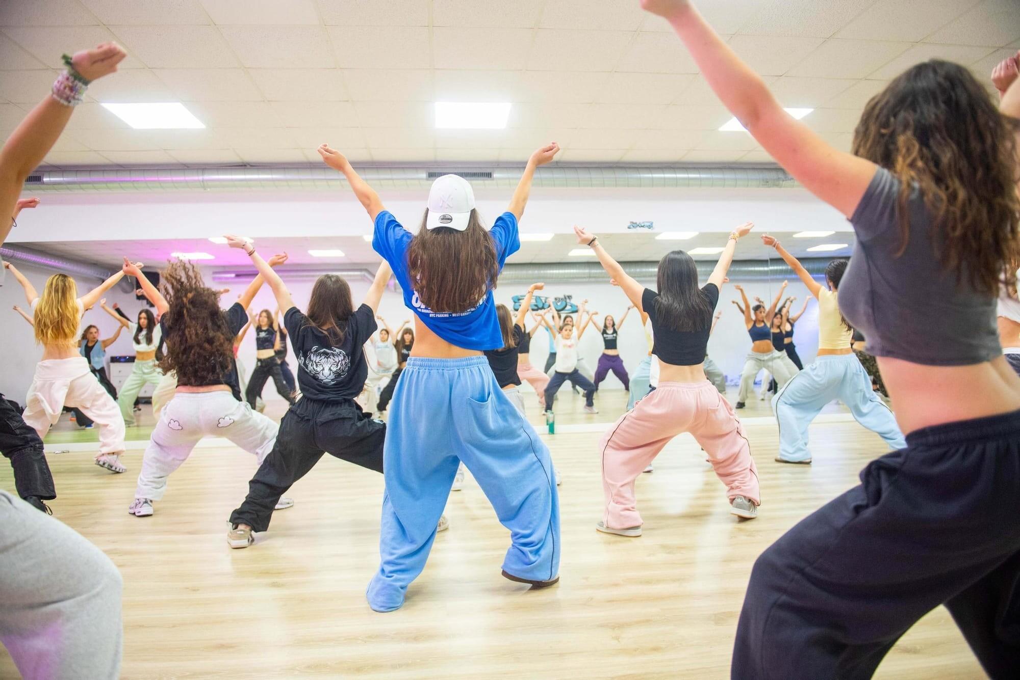 Clase de K-pop en The Vibe Studio: alumnas bailando en el aula, de espaldas, con los brazos arriba
