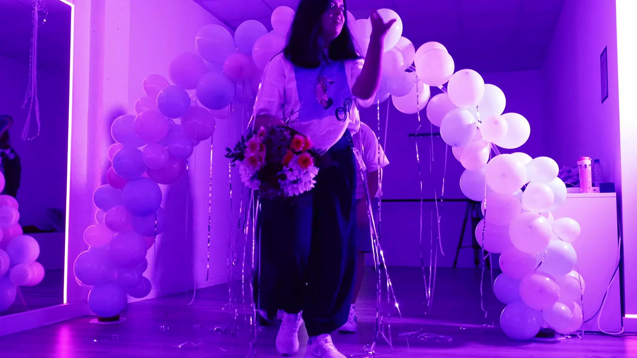 Arco de globos blancos y morados en la entrada de la fiesta