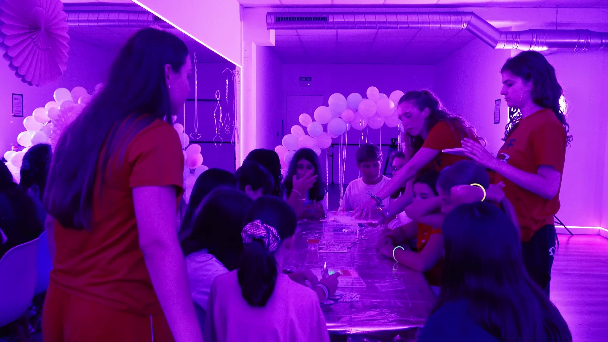 Mesa de manualidades junto al arco de globos, con las monitoras