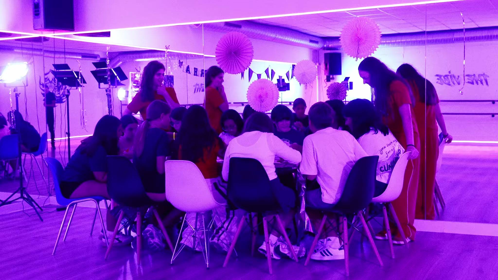 Niñas y niños sentados en corro en la sala de baile