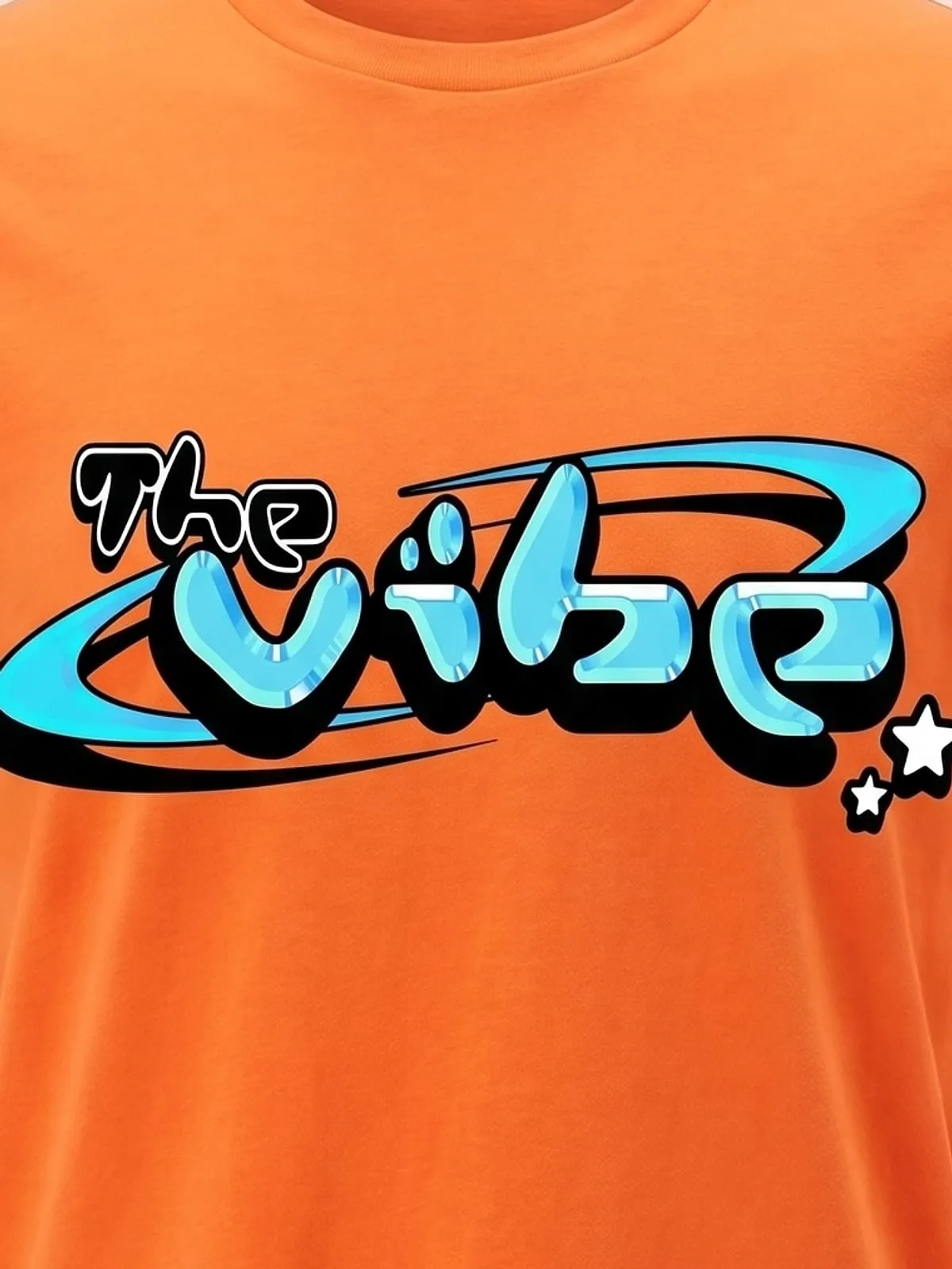 Detalle del logo de The Vibe en cian estampado en la camiseta naranja