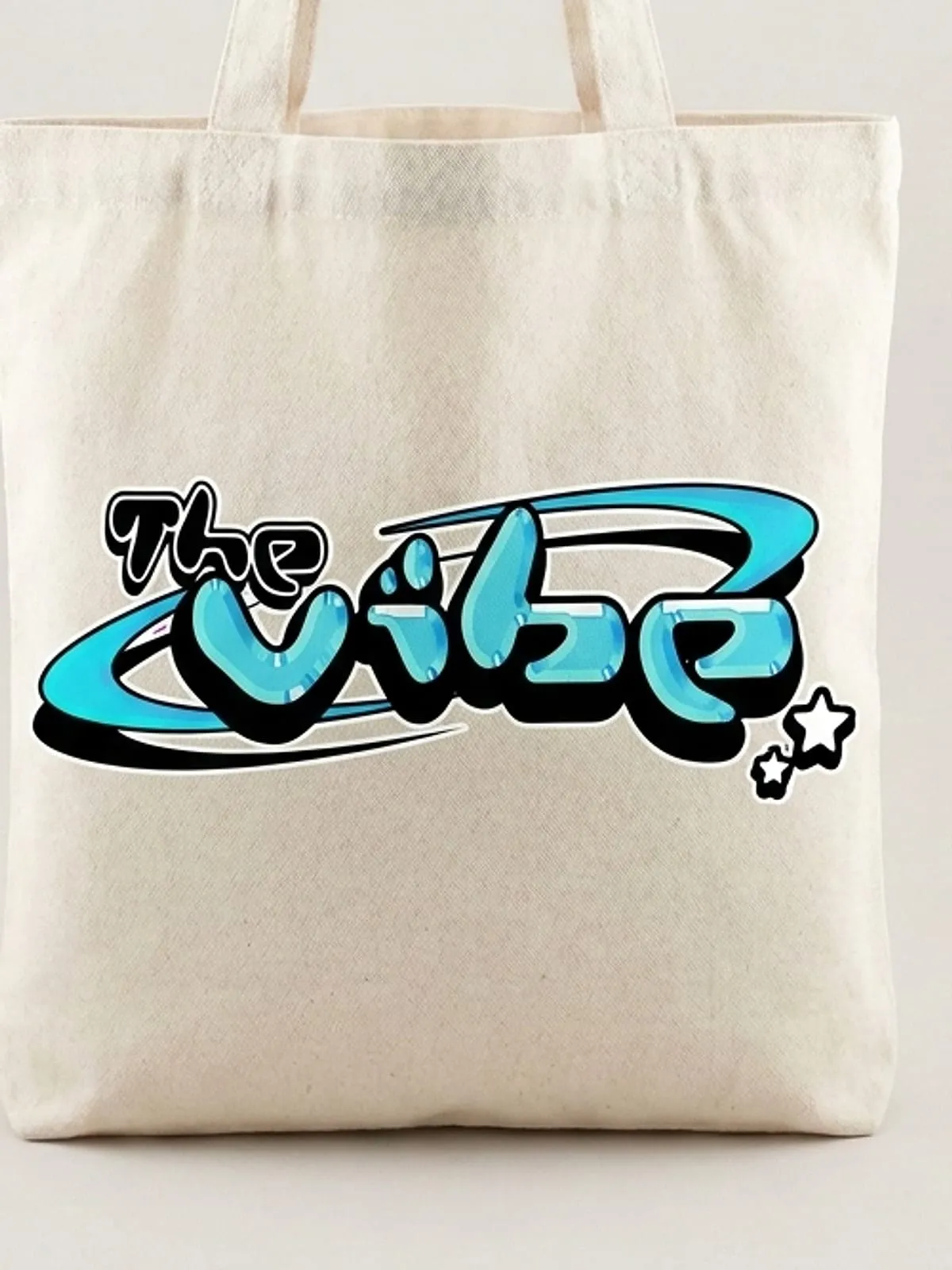 Detalle del logo de The Vibe en cian estampado en la bolsa de lona cruda