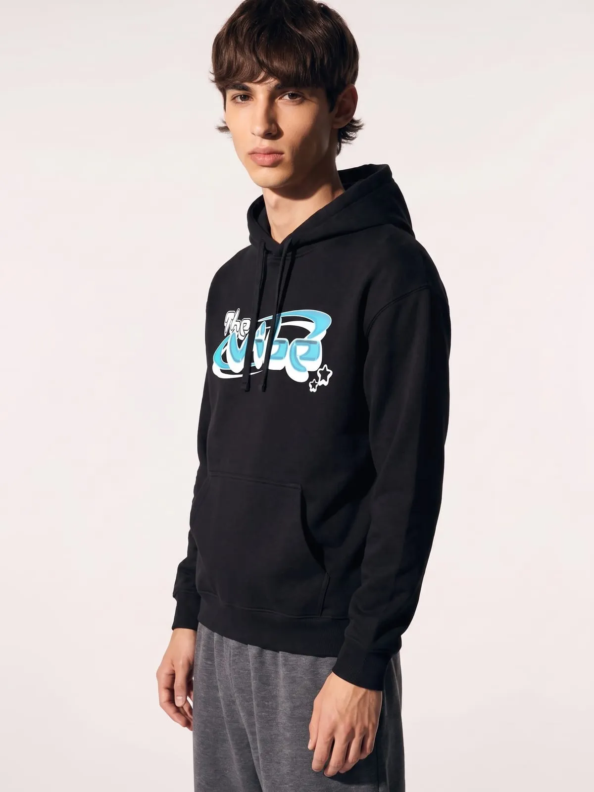 Modelo con la sudadera con capucha negra de The Vibe, de tres cuartos