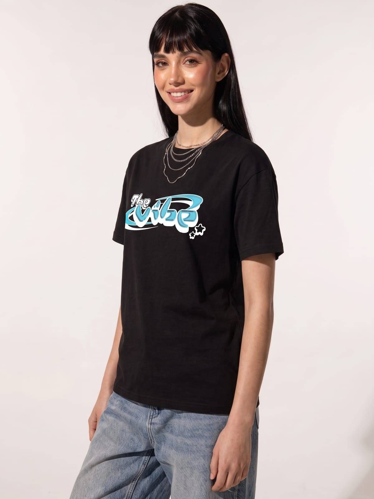 Chica con flequillo y la camiseta negra de The Vibe, de tres cuartos