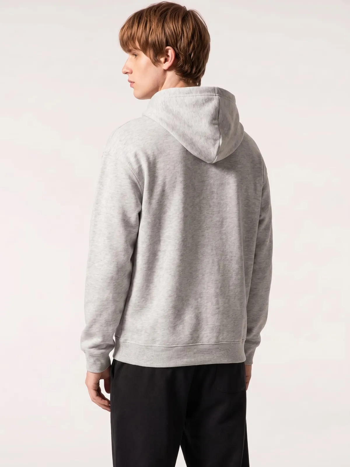 Modelo con la sudadera con capucha gris de The Vibe, de espaldas