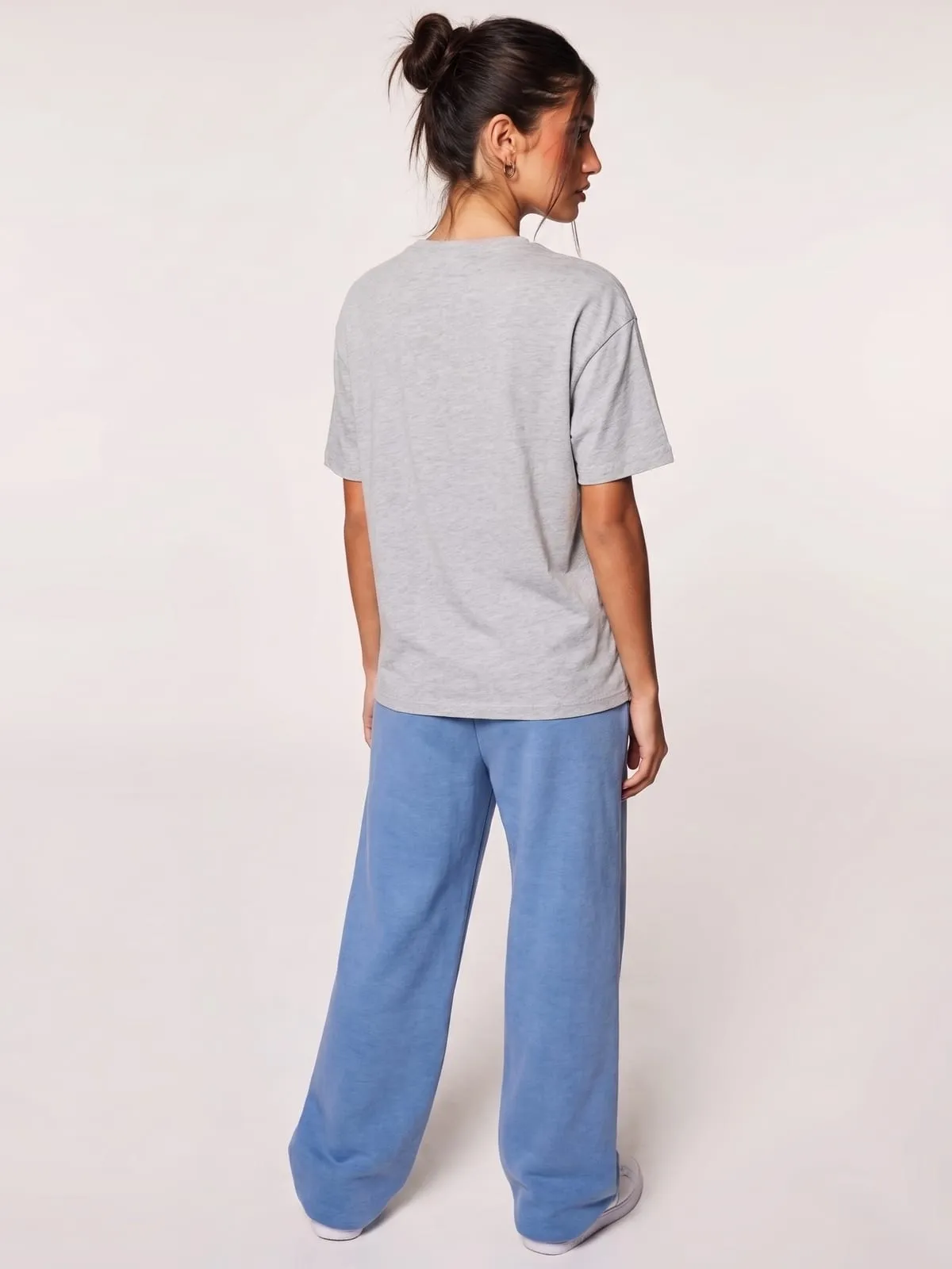 Modelo con la camiseta gris jaspeada de The Vibe, de espaldas