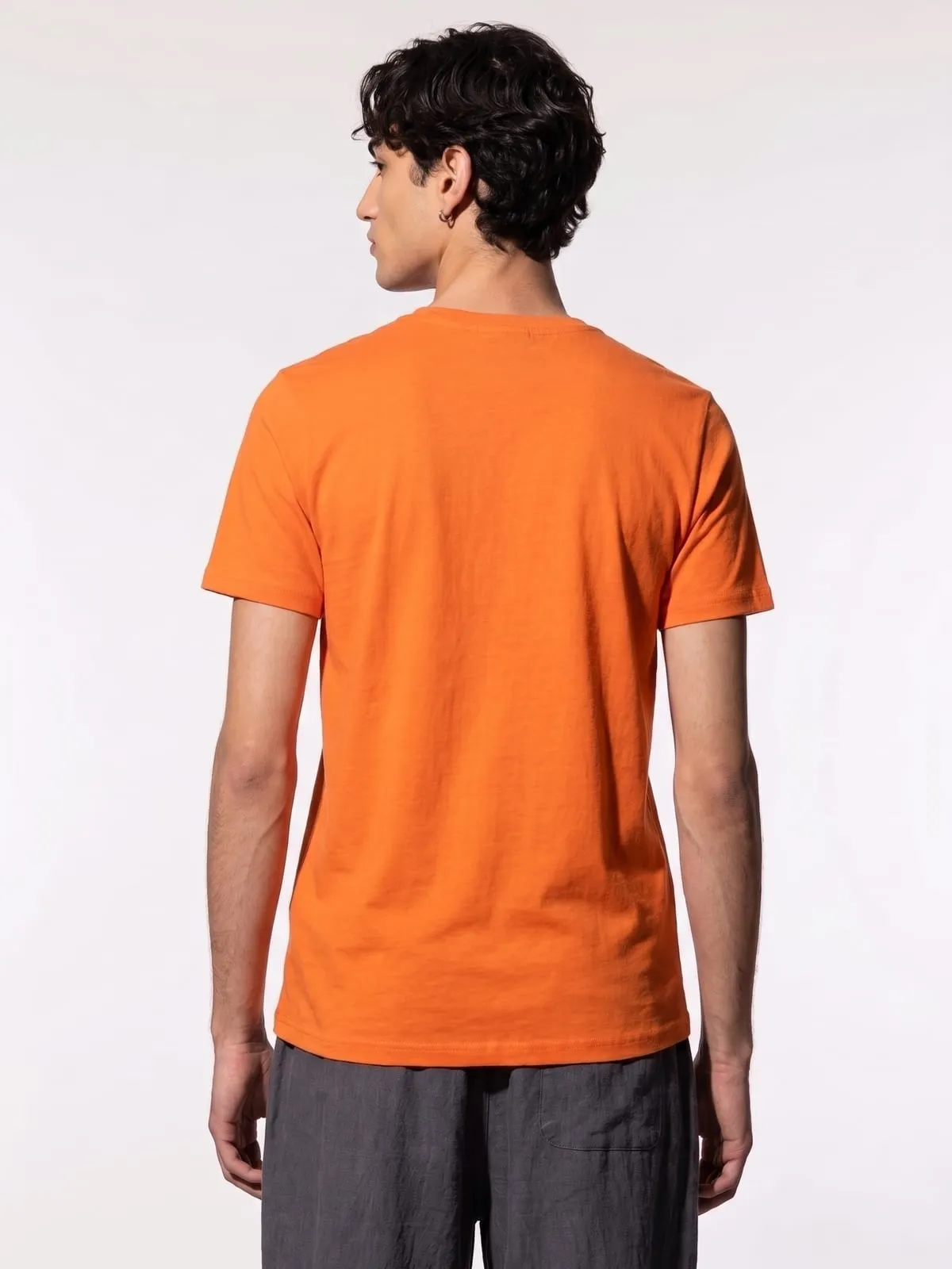 Modelo con la camiseta naranja de The Vibe, de espaldas