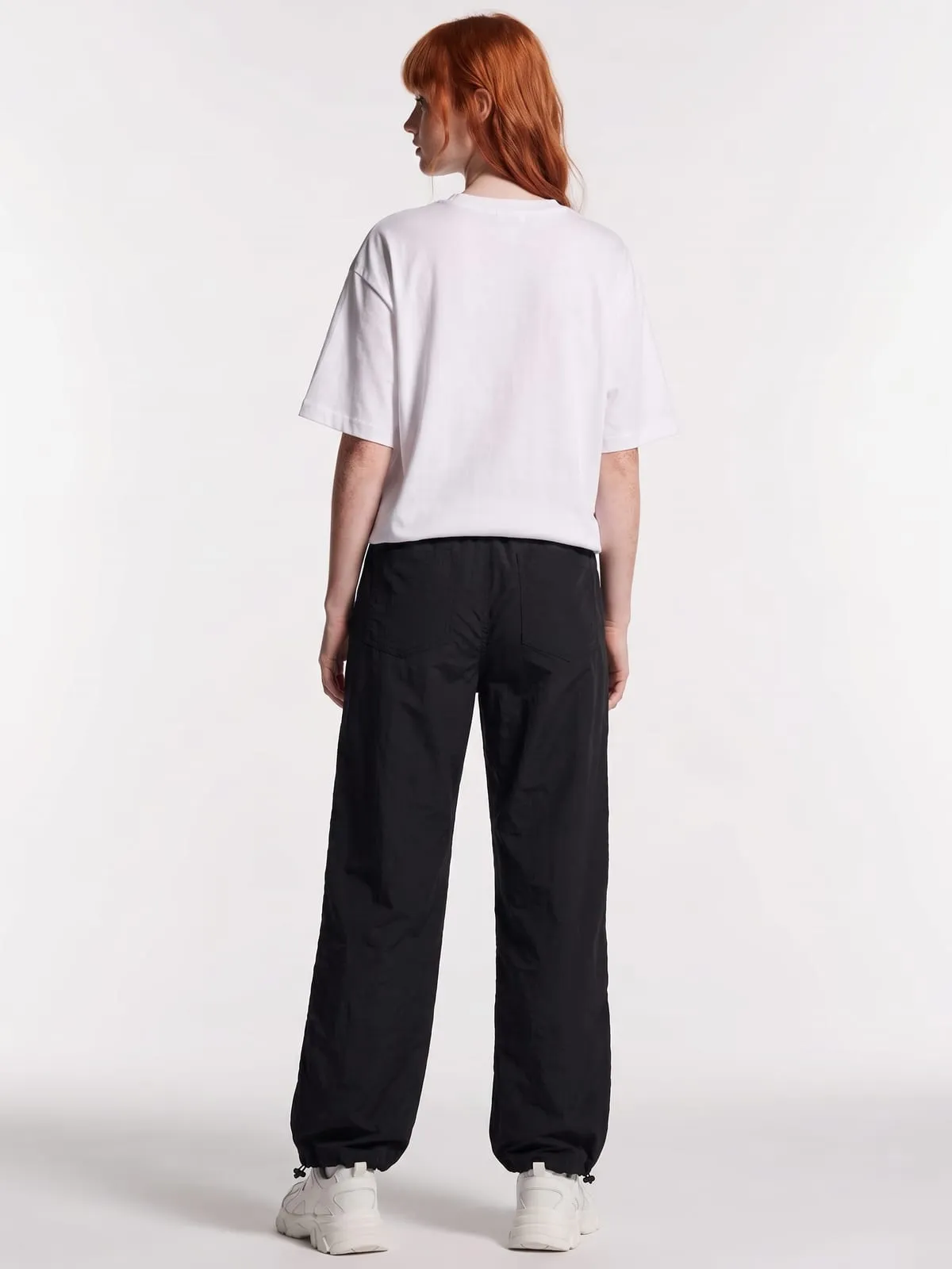 Modelo con el pantalón ancho negro de The Vibe, de espaldas