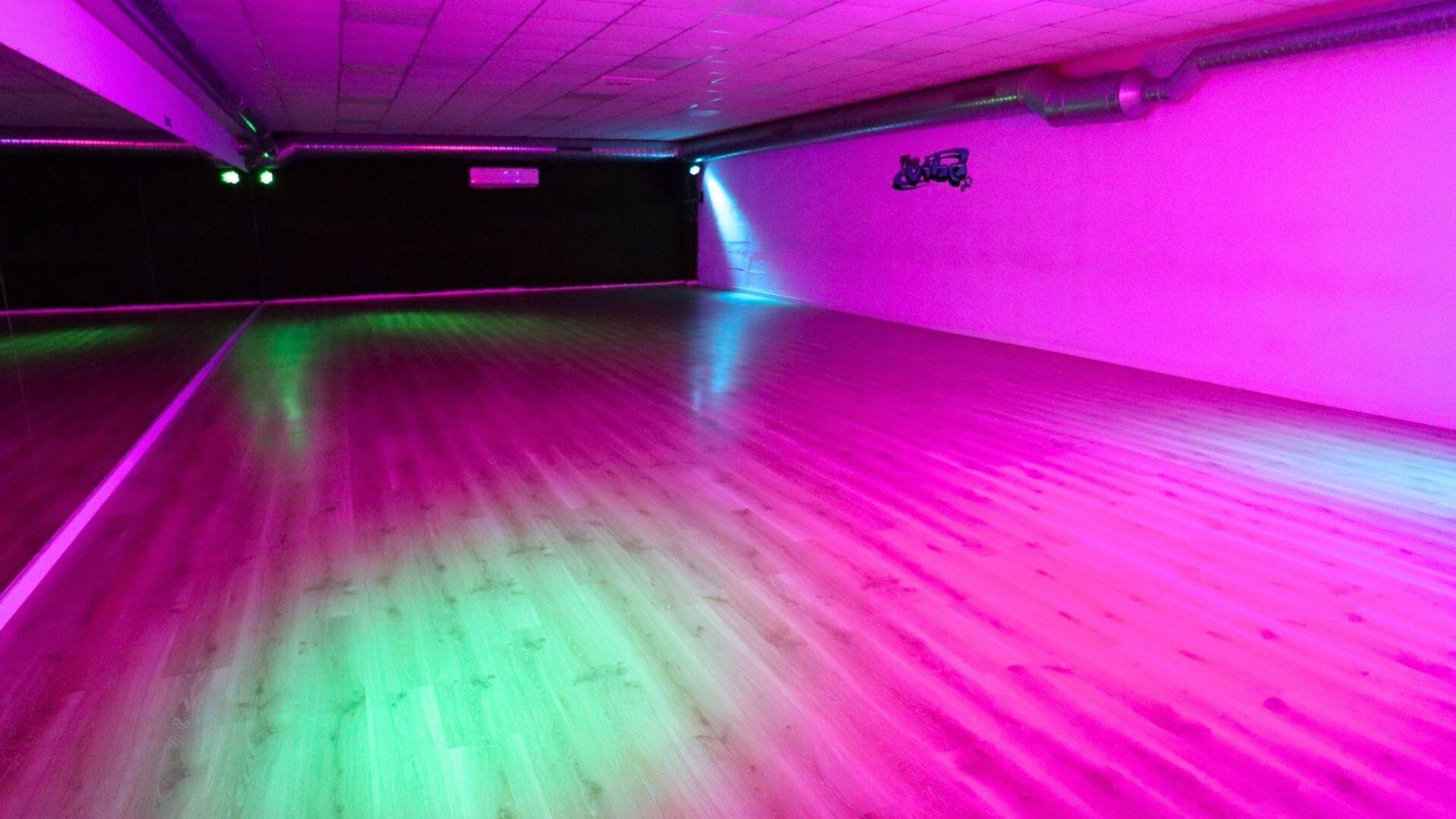 Una sala de The Vibe Studio con las luces de colores encendidas